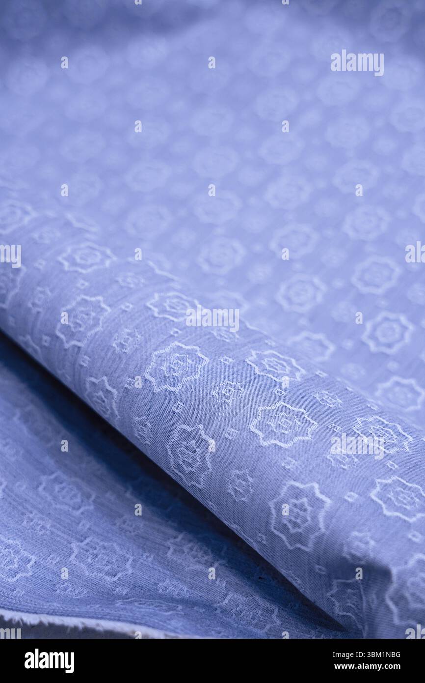 Vue rapprochée d'un luxueux tissu bleu clair avec un motif tissé complexe. La texture est douce et subtile, idéale pour les arrière-plans, textiles ou F. Banque D'Images