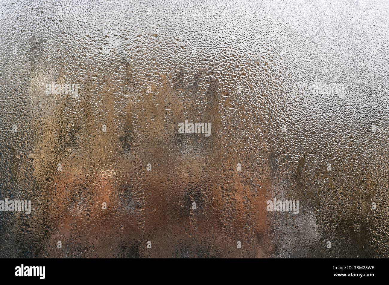 L'abstraction atmosphérique se forme lorsque la condensation dessine des motifs liquides sur le verre. La fenêtre devient une démonstration de l'art aquatique de la nature. fond de verre humide. Banque D'Images