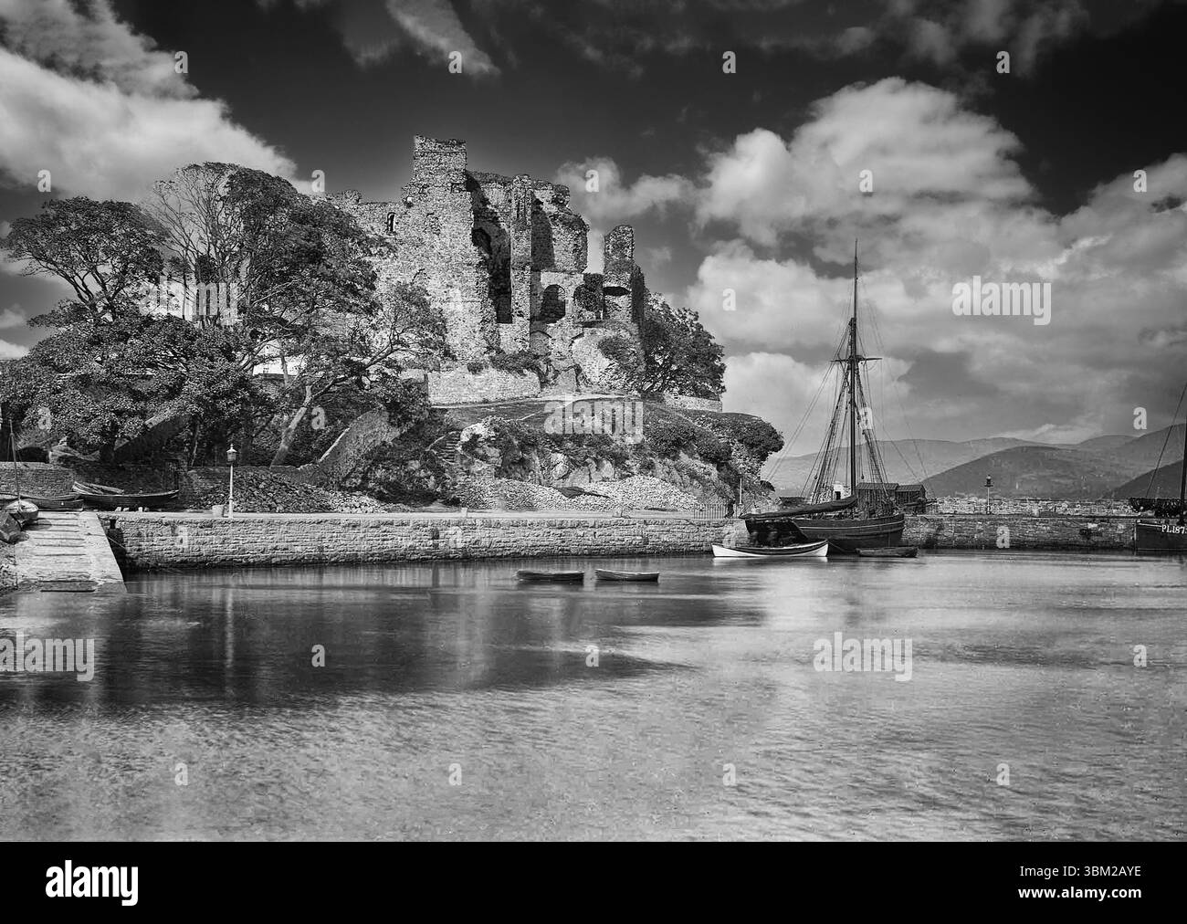 Photographie de la fin du XIXe siècle d'un voilier en bois amarré sur les quais en dessous du château du roi John en ruine à Carlingford, comté de Louth, Irlande. Construit à la fin du XIIe siècle par Hugh de Lacy, seigneur de Meath peu après l'invasion normande de l'Irlande. Il a acquis son nom après que le roi Jean y est censé rester trois jours en 1210, lors de sa deuxième expédition, quand il a envahi l'Ulster pour appréhender Said Hugh de Lacy. Plus tard, à la suite de la bataille de la Boyne, les Jacobites tirèrent sur le château en 1689 lorsque Guillaume d'Orange aurait hébergé ses soldats blessés. Banque D'Images