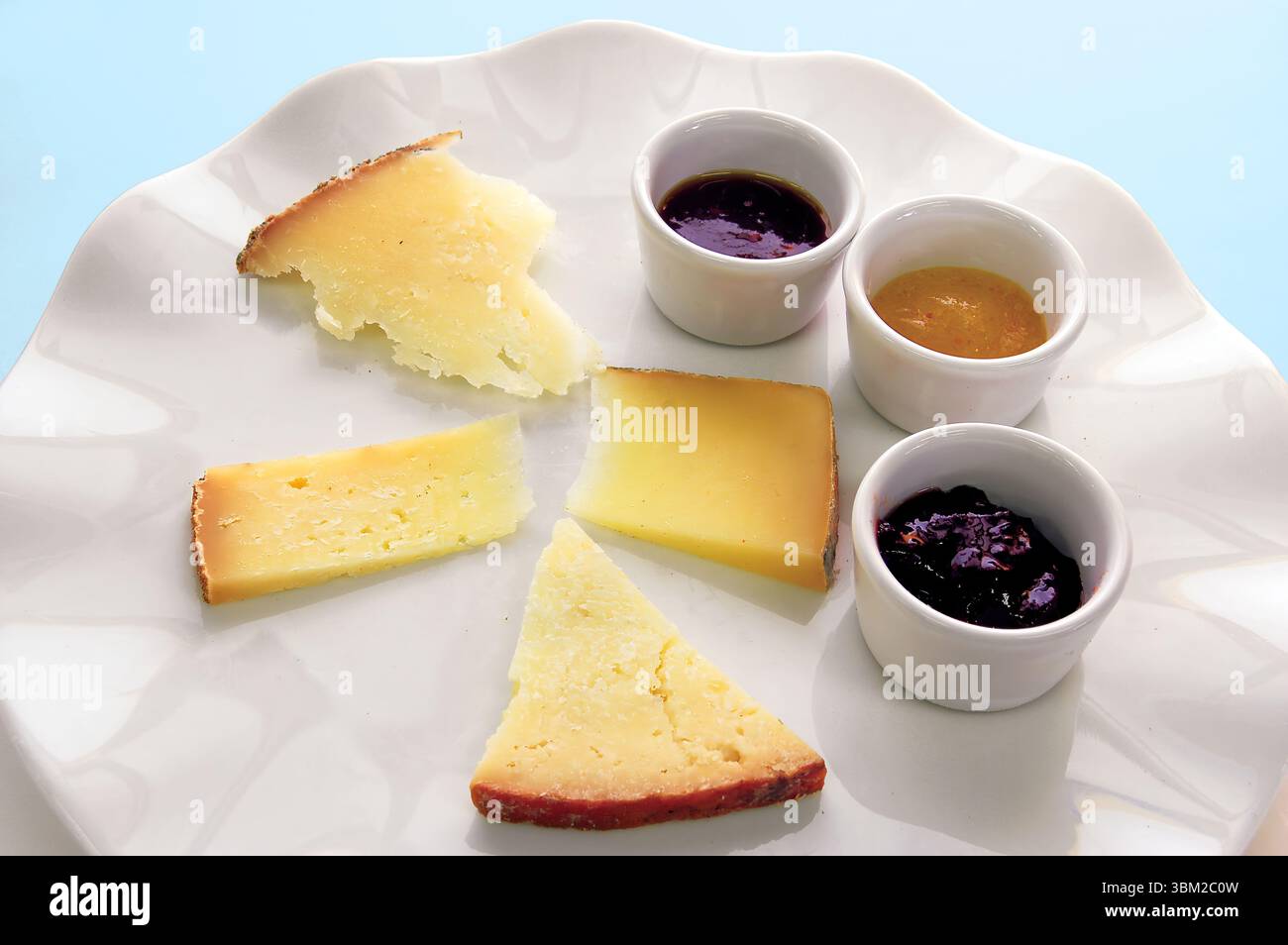Différents types de fromages servis avec du miel et de la confiture, créant une délicieuse combinaison de saveurs et de textures, parfaite pour une expérience de dégustation Banque D'Images