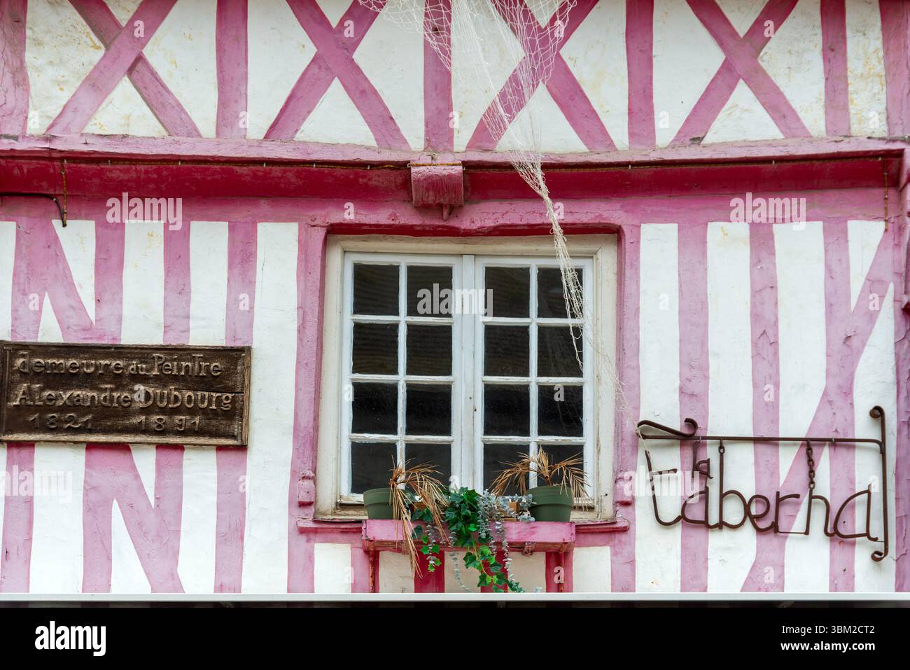 Fenêtre d'un joli bâtiment rose à colombages occupé par le café/bar la Taberna avec plaque commémorative au peintre Alexandre Dubourg 1821-1891 Banque D'Images