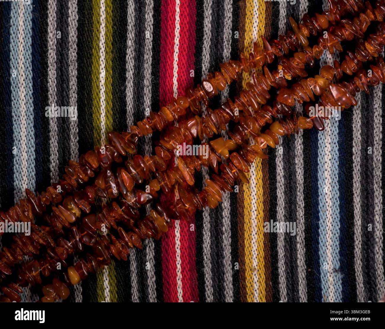 Perles ambrées doublées en diagonale sur tissu de laine rayé coloré Banque D'Images