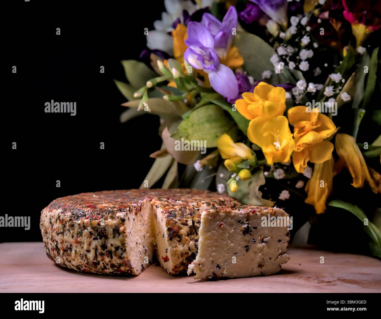 Fromage traditionnel letton sur assiette en bois avec des fleurs sur le fond Banque D'Images