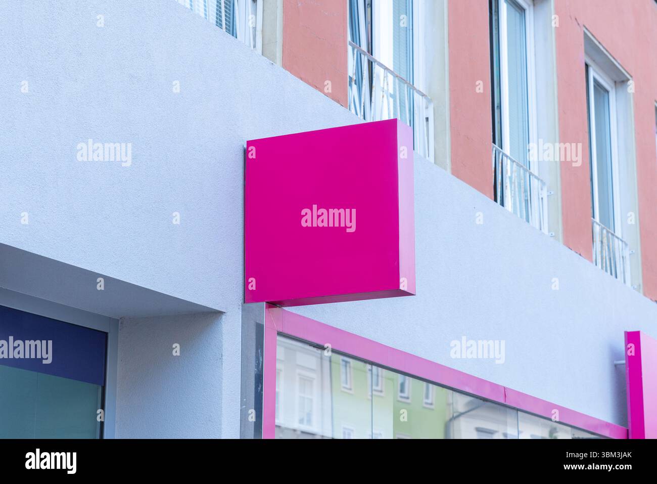 Signalisation carrée rose sur la façade moderne du bâtiment, parfaite pour la mode, la beauté ou les maquettes de marque de détail dans les concepts de présentation d'entreprise urbaine Banque D'Images