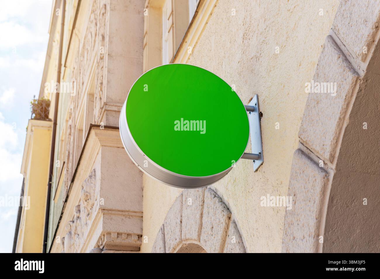 Maquette de panneau vert rond sur le mur de pierre à la lumière du jour, parfait pour la marque, l'identité, le logo ou la promotion de la vitrine Banque D'Images