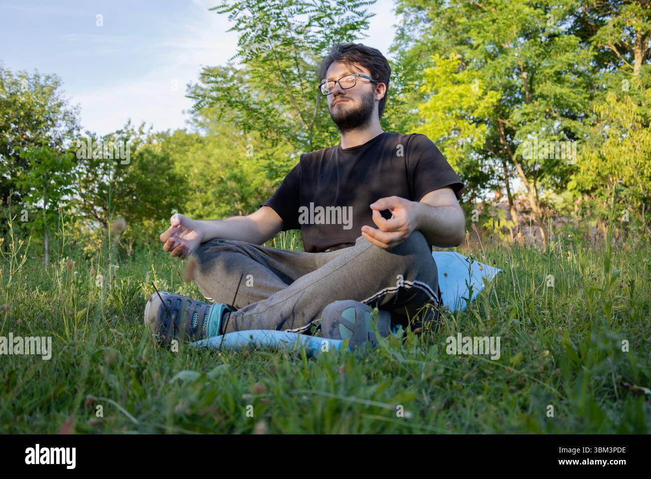Homme conscient méditant dans la nature au lever du soleil Banque D'Images