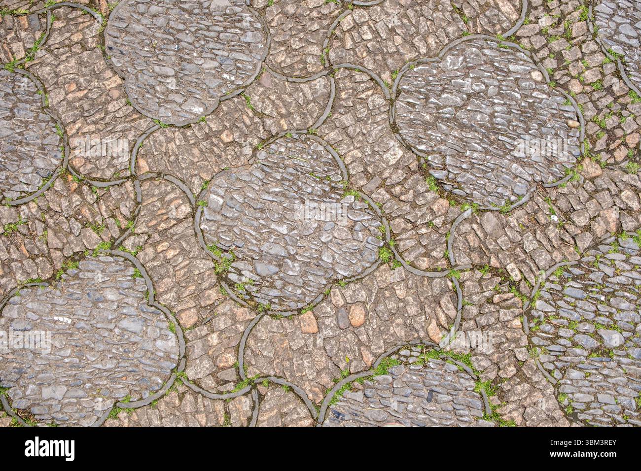 Fond de pavé traditionnel, pierres de rivière lisses disposées en motif. Ancien pavage de jardin chinois, texture vieillie Banque D'Images