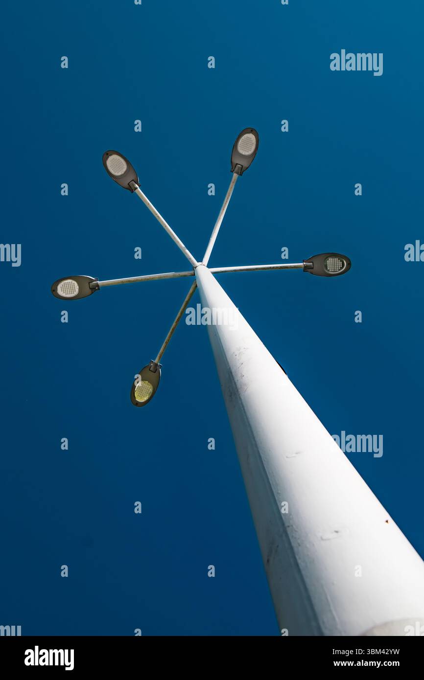 Un grand lampadaire se dresse bien en évidence, avec de multiples lumières s'étendant à partir d'un poteau central. Banque D'Images