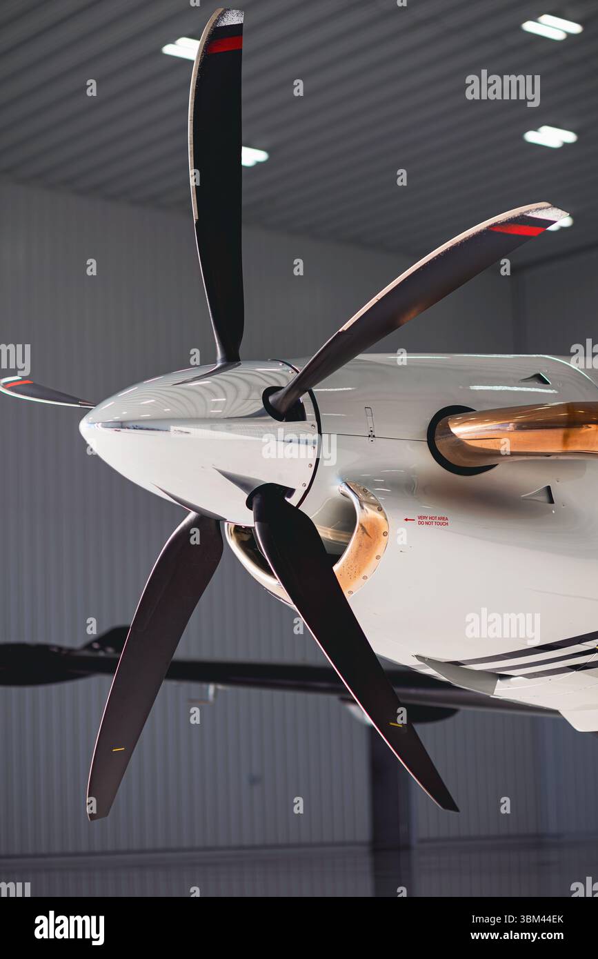 Macro gros plan d'une hélice et d'un spinner d'avion monomoteur turbopropulsé, capturé à l'intérieur d'un hangar avec éclairage directionnel et surface détaillée te Banque D'Images