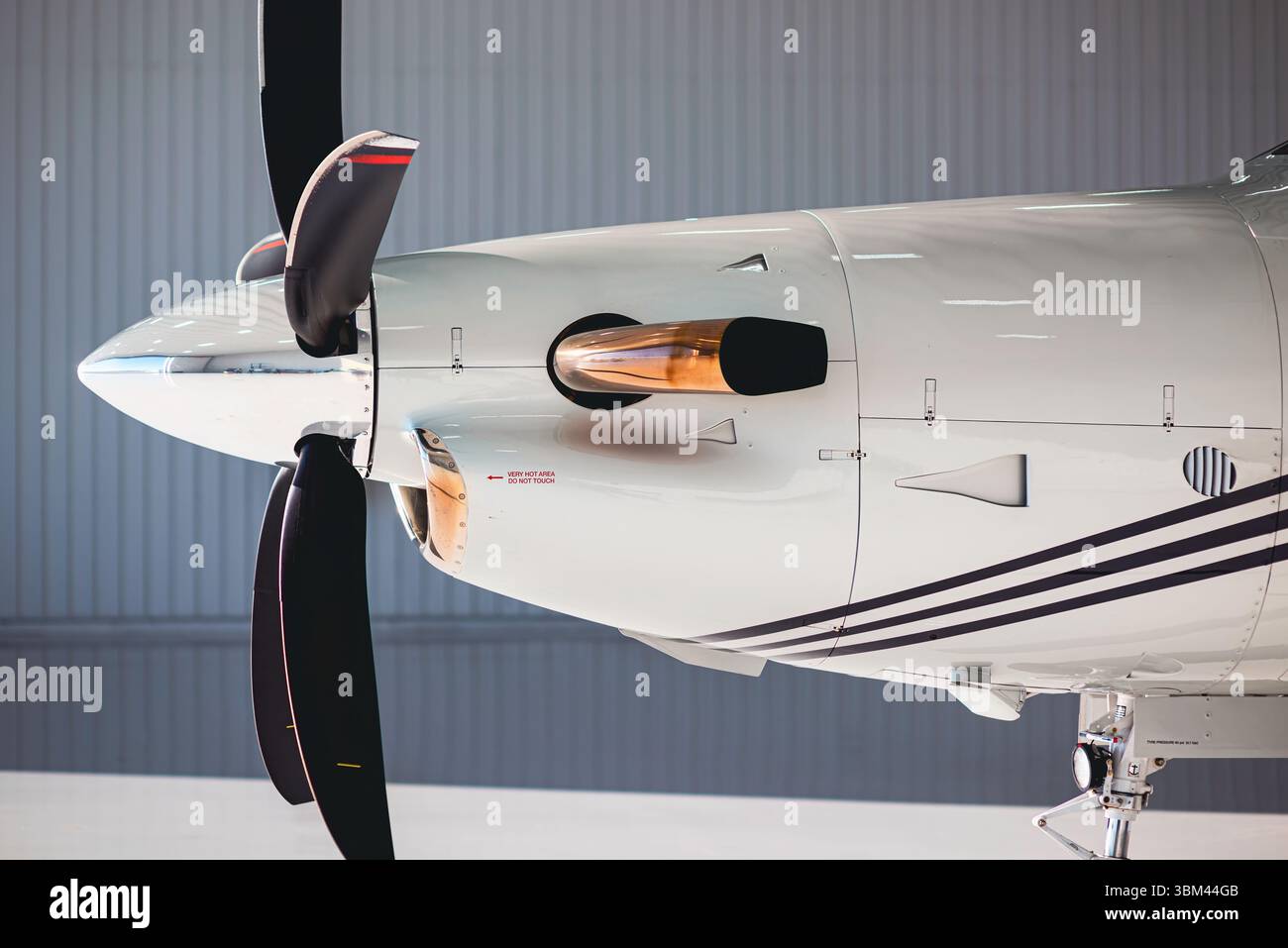 Vue latérale large d'une hélice, d'une turbine et d'un échappement d'avion turbopropulsé avec paroi de hangar réfléchissante et éclairage naturel de l'espace de copie. Banque D'Images