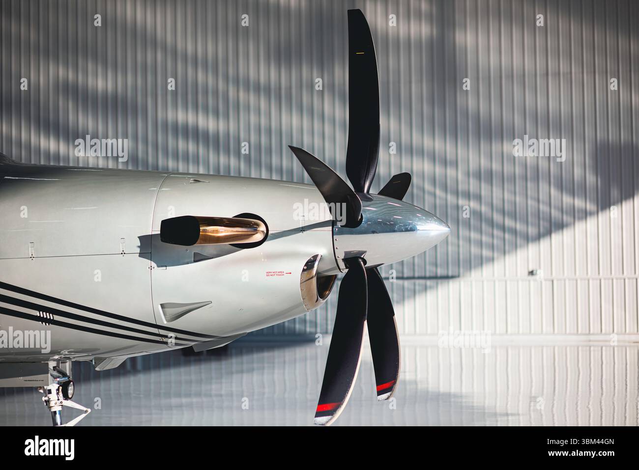 Vue latérale d'une hélice, d'une turbine et d'un échappement d'avion turbopropulsé avec paroi de hangar réfléchissante et éclairage naturel de l'espace de copie. Banque D'Images