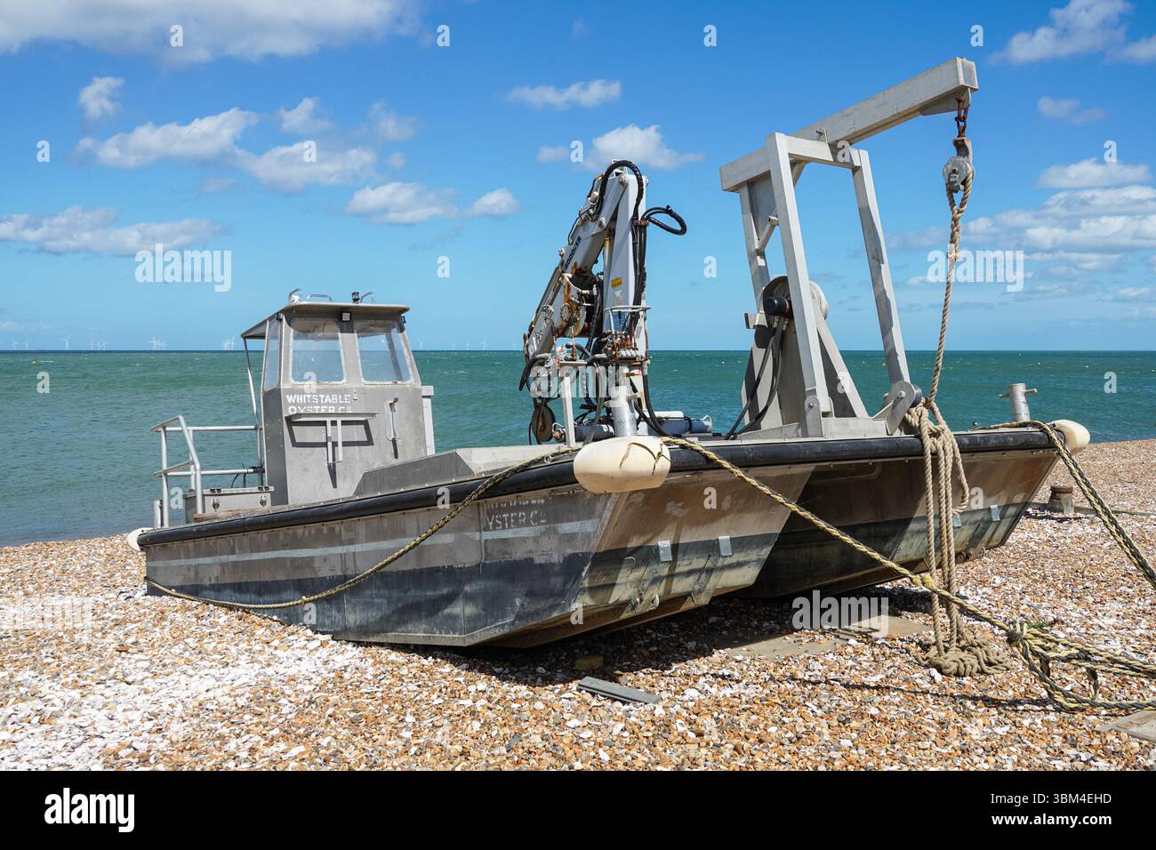 Bateau de pêche aux huîtres sur une plage à Whitstable, Kent, Angleterre Royaume-Uni Banque D'Images