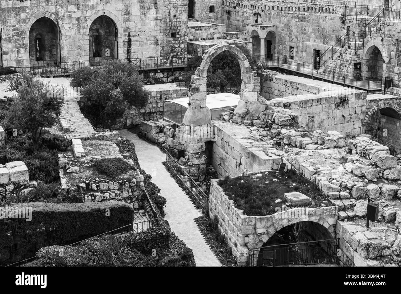 Une cour avec une arche en pierre et un mur en pierre. La cour est vide et a une atmosphère très ancienne et historique à elle Banque D'Images
