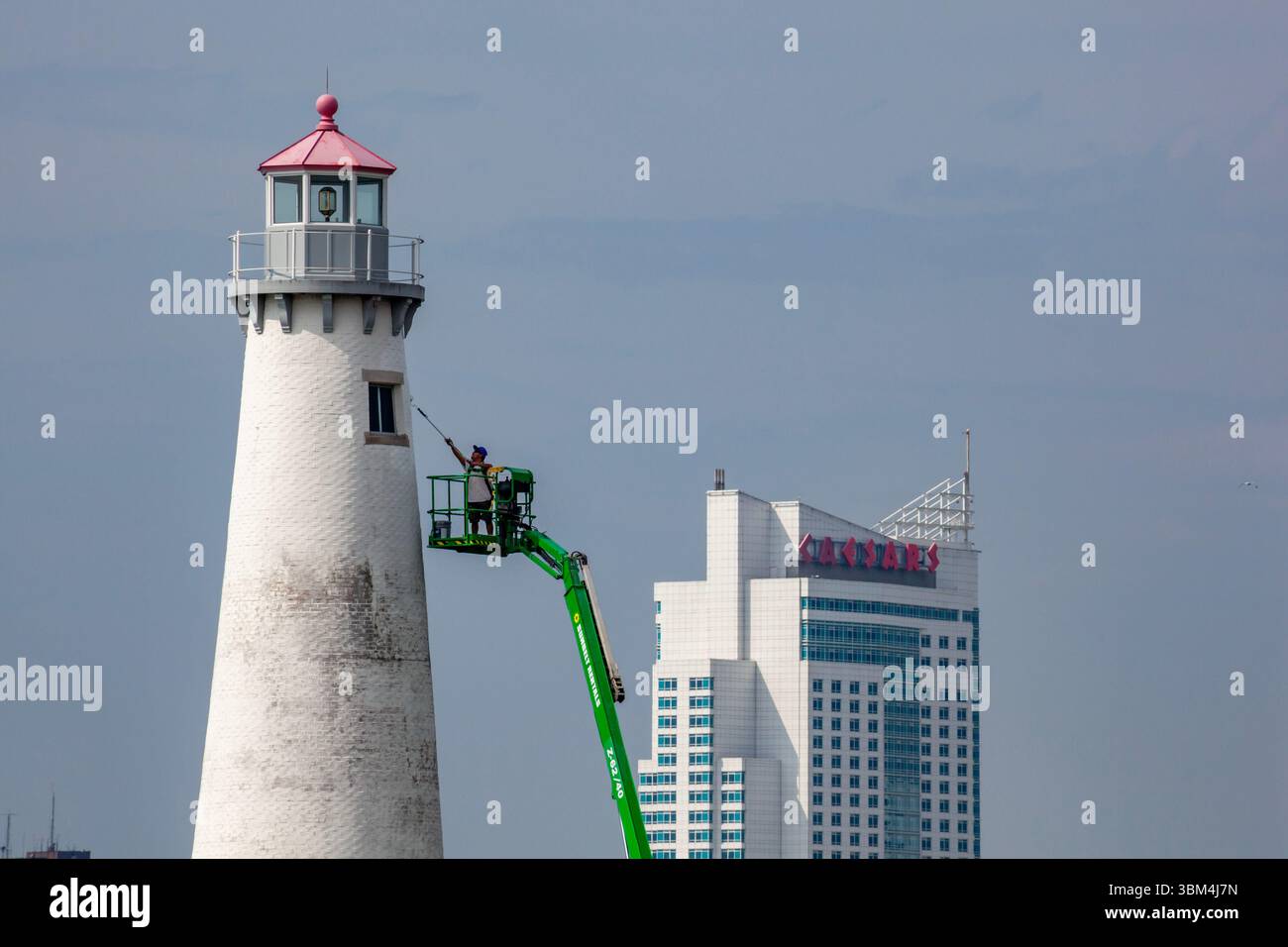 Detroit, Michigan - Un travailleur sur un ascenseur peint le phare du parc d'État de Milliken. Le phare est situé sur la rivière Détroit, près du centre-ville de Détroit. Le C Banque D'Images