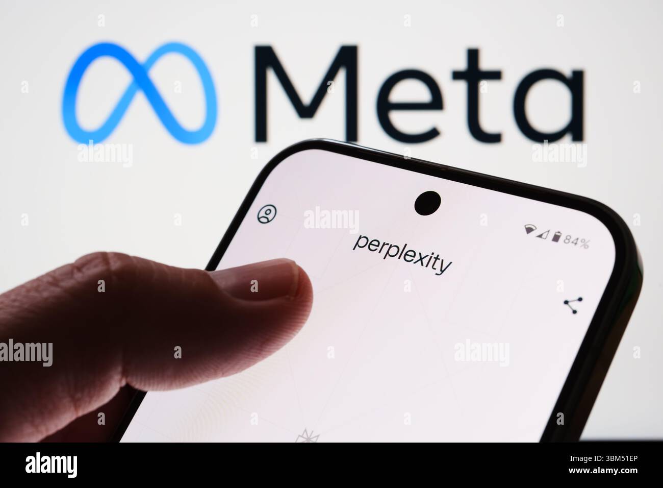 Écran d'interface perplexité sur le téléphone devant le logo Meta avec le doigt de l'utilisateur visible. Stafford, Royaume-Uni, 24 juin 2025 Banque D'Images