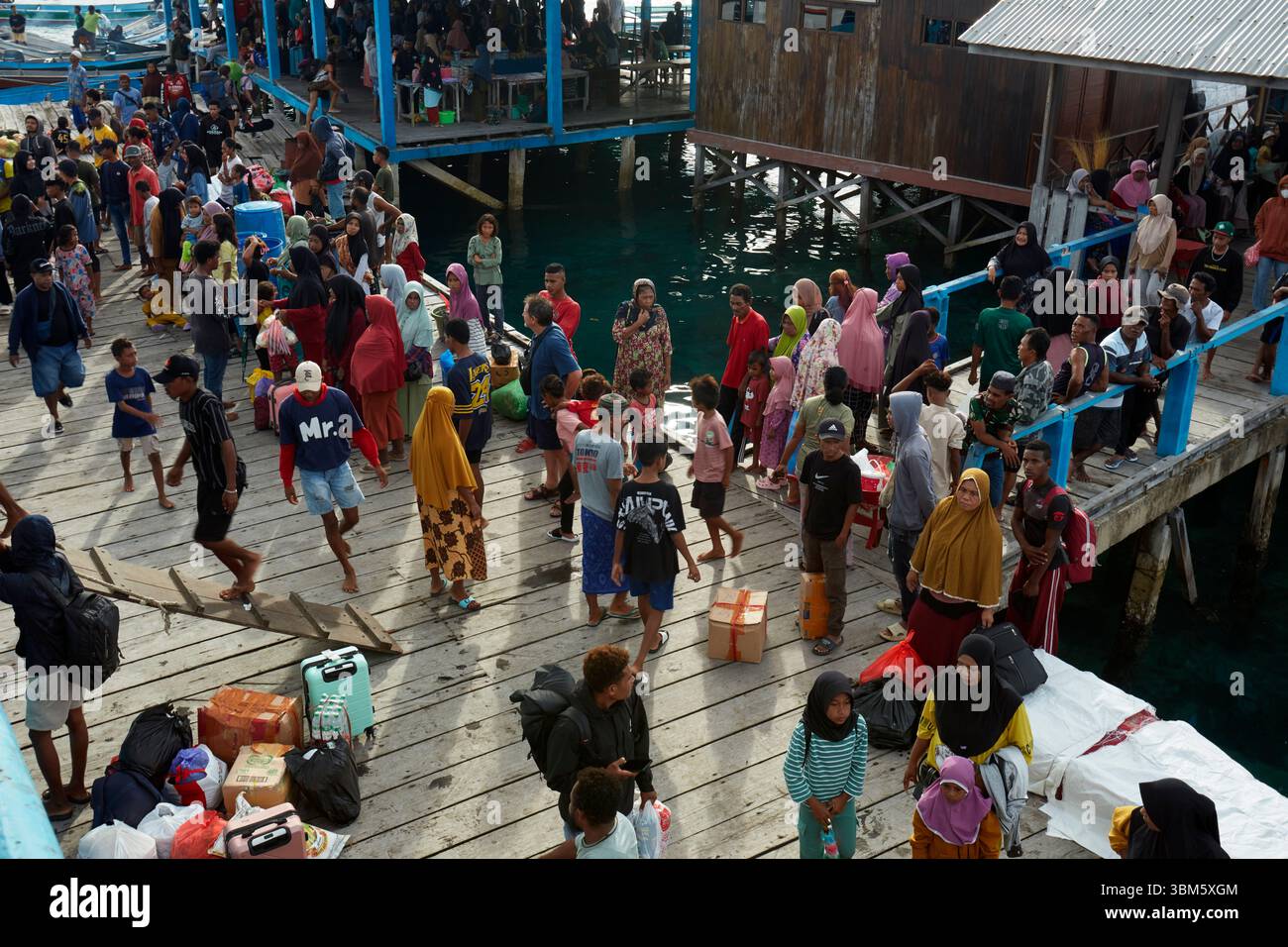 Les gens rencontrant le ferry hebdomadaire, Port de Yellu, île de Yellu, Misool, Raja Ampat, Papouasie du Sud-Ouest, Indonésie Banque D'Images
