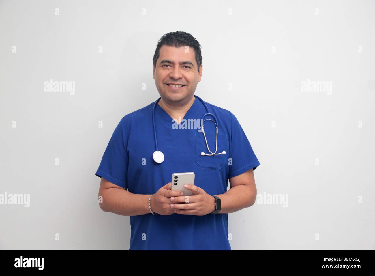 Un médecin latino-américain à la peau foncée avec un stéthoscope montre son téléphone portable pour avoir des consultations en ligne avec ses patients Banque D'Images Un médecin latino-américain à la peau foncée avec un stéthoscope montre son téléphone portable pour avoir des consultations en ligne avec ses patients Banque D'Images