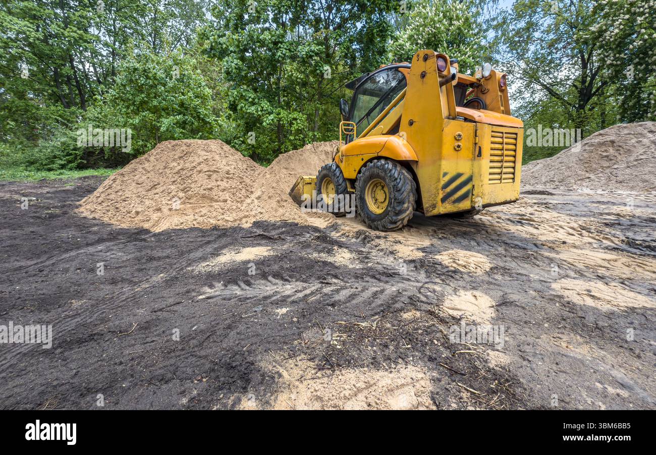 excavatrice de chargeur compact rigide en travaux de construction. mini chargeur déplace la terre sur le chantier de construction. Banque D'Images