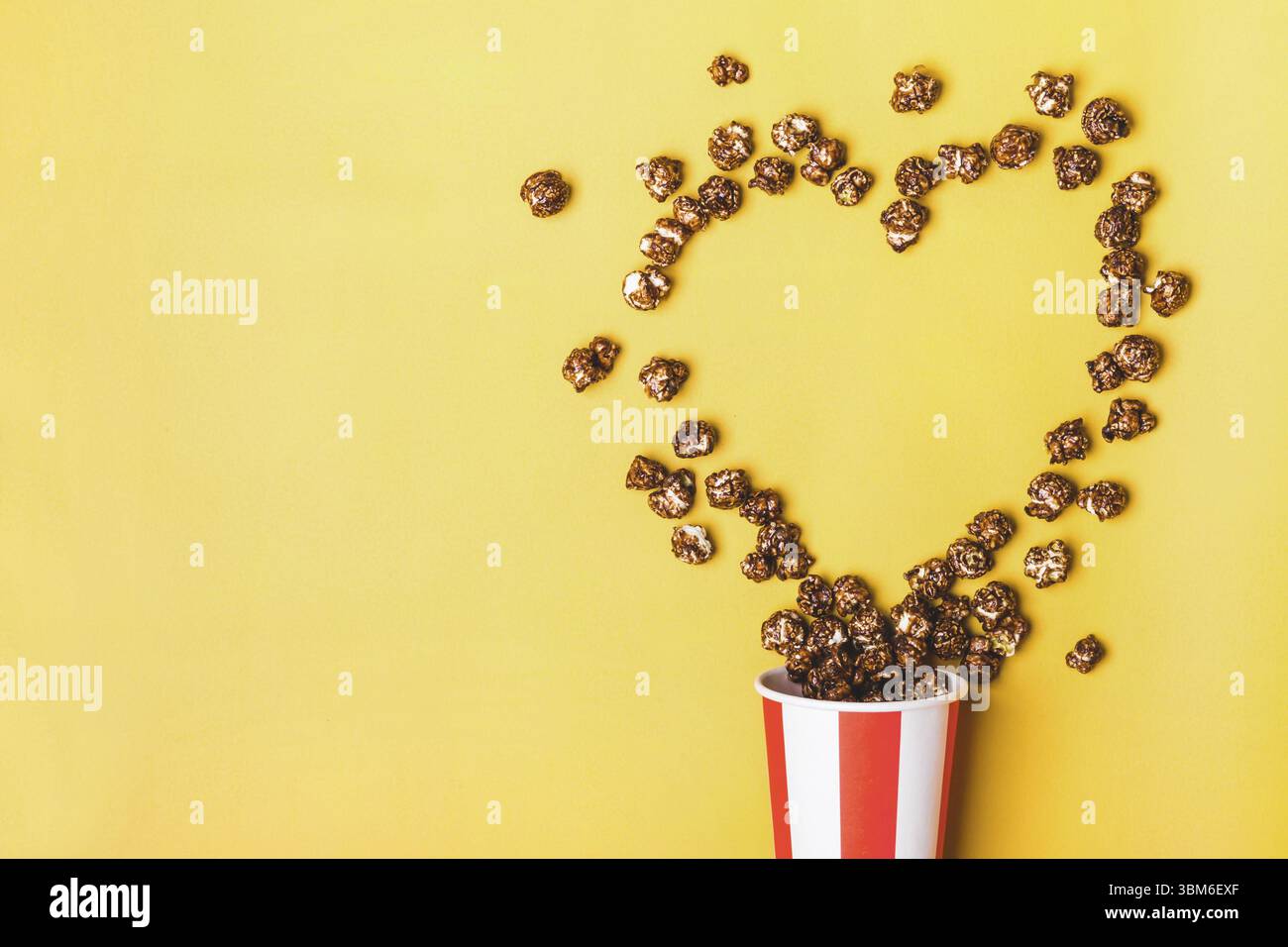 Pop-corn au chocolat doux dans une tasse rouge blanche rayée de papier Banque D'Images