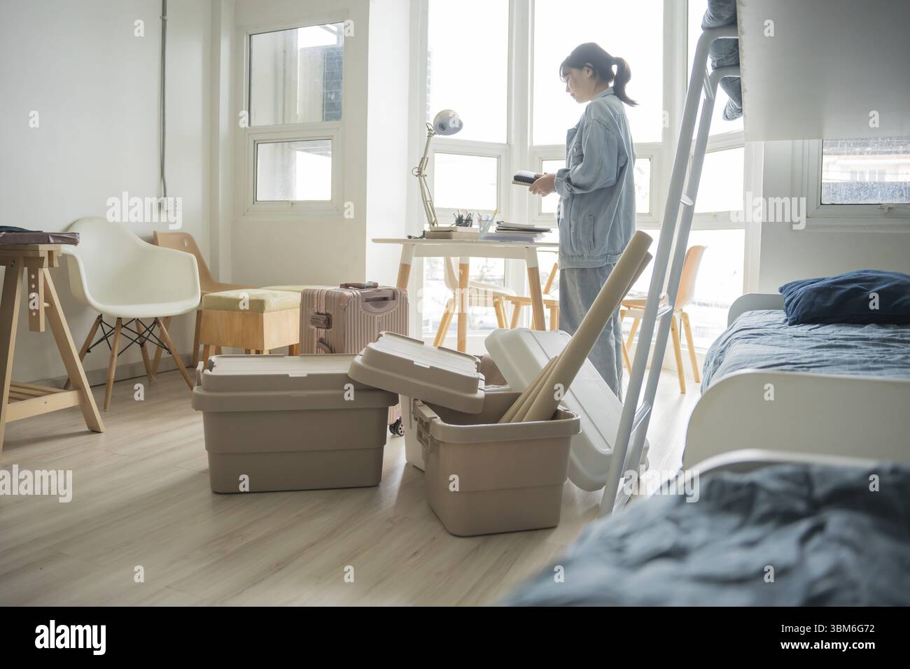 Étudiante femme asiatique organiser la chambre déballage dans la chambre de dortoir étudiant collégial se déplaçant vers le nouveau dortoir universitaire ou se préparant à déménager Banque D'Images