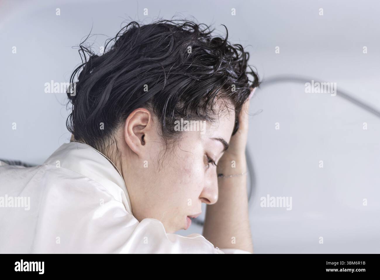 Portrait d'une jeune femme latine se lavant les cheveux avec la douche à la maison pour se détendre et garder ses cheveux propres Banque D'Images