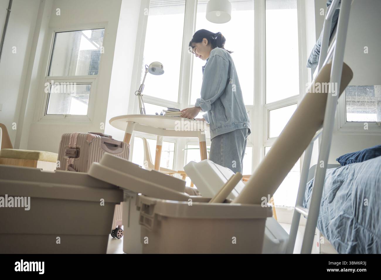 Étudiante femme asiatique organiser la chambre déballage dans la chambre de dortoir étudiant collégial se déplaçant vers le nouveau dortoir universitaire ou se préparant à déménager Banque D'Images