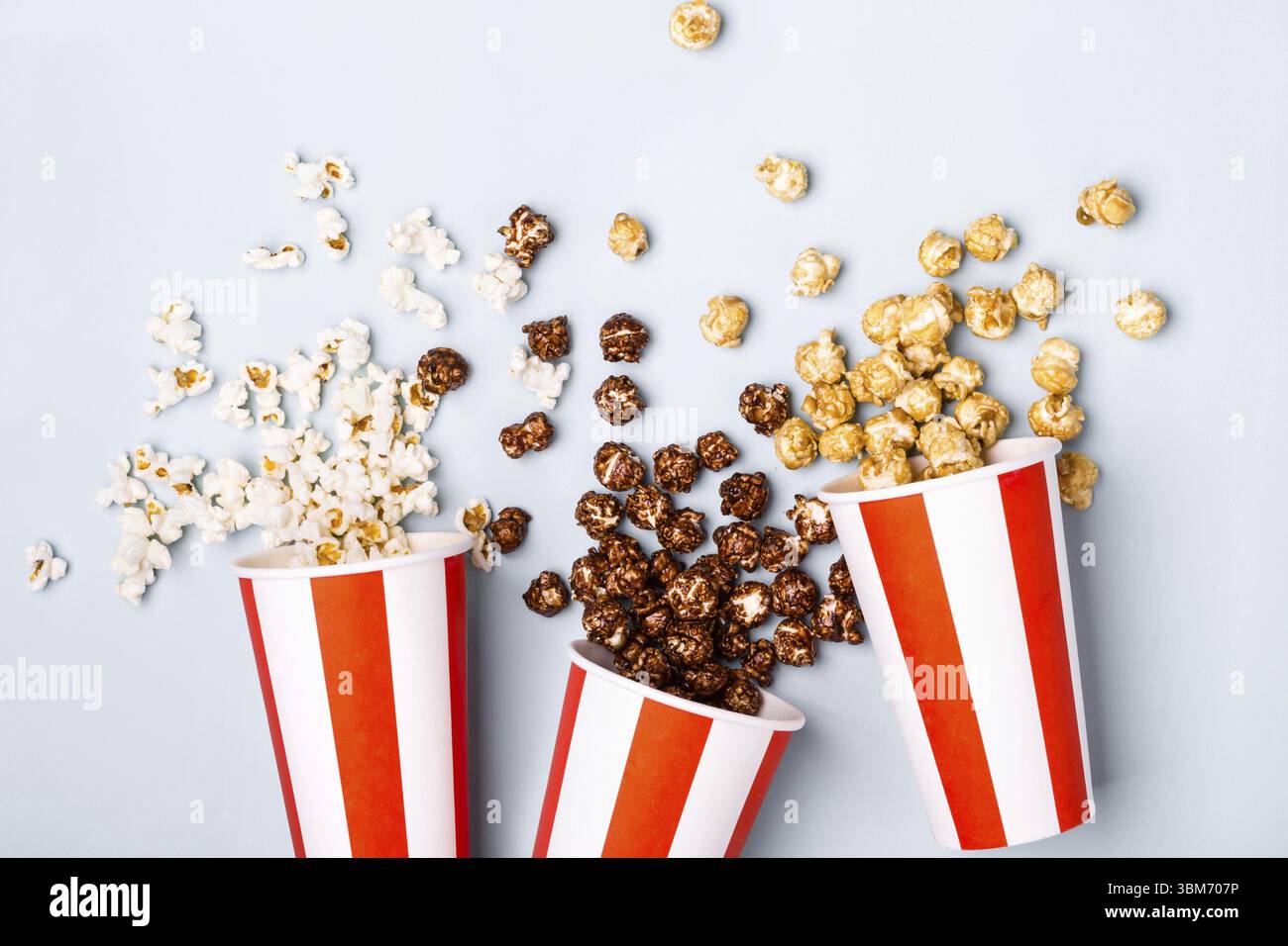 Assortiment de pop-corn dans une tasse rouge blanche rayée en papier. Pop-corn sucré et salé Banque D'Images