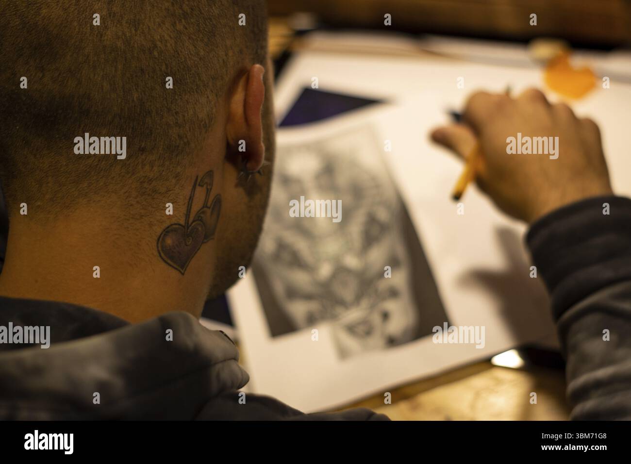 Portrait d'un maître calligraphe. Un tatoueur fait un croquis assis à une table dans le Studio. Mise au point sélective Banque D'Images