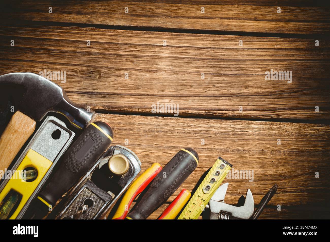 Des outils à main assortis sont disposés sur une surface de planche de bois chaude dans un design plat Banque D'Images Des outils à main assortis sont disposés sur une surface de planche de bois chaude dans un design plat Banque D'Images