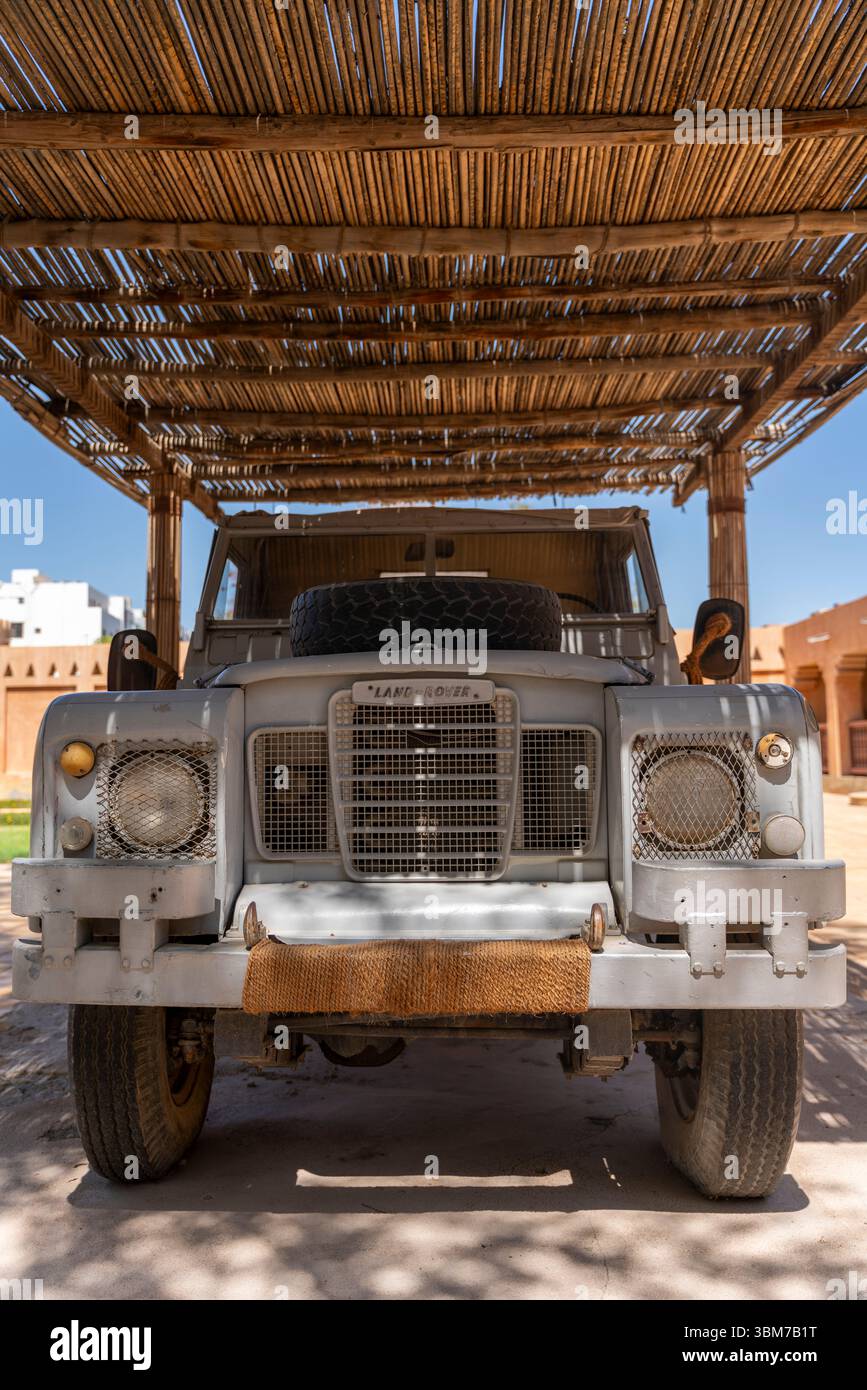 Camion vintage garé sous un abri en bois entouré de palmiers, emplacement Al Ain Palace Museum, Emirats Arabes Unis. Banque D'Images
