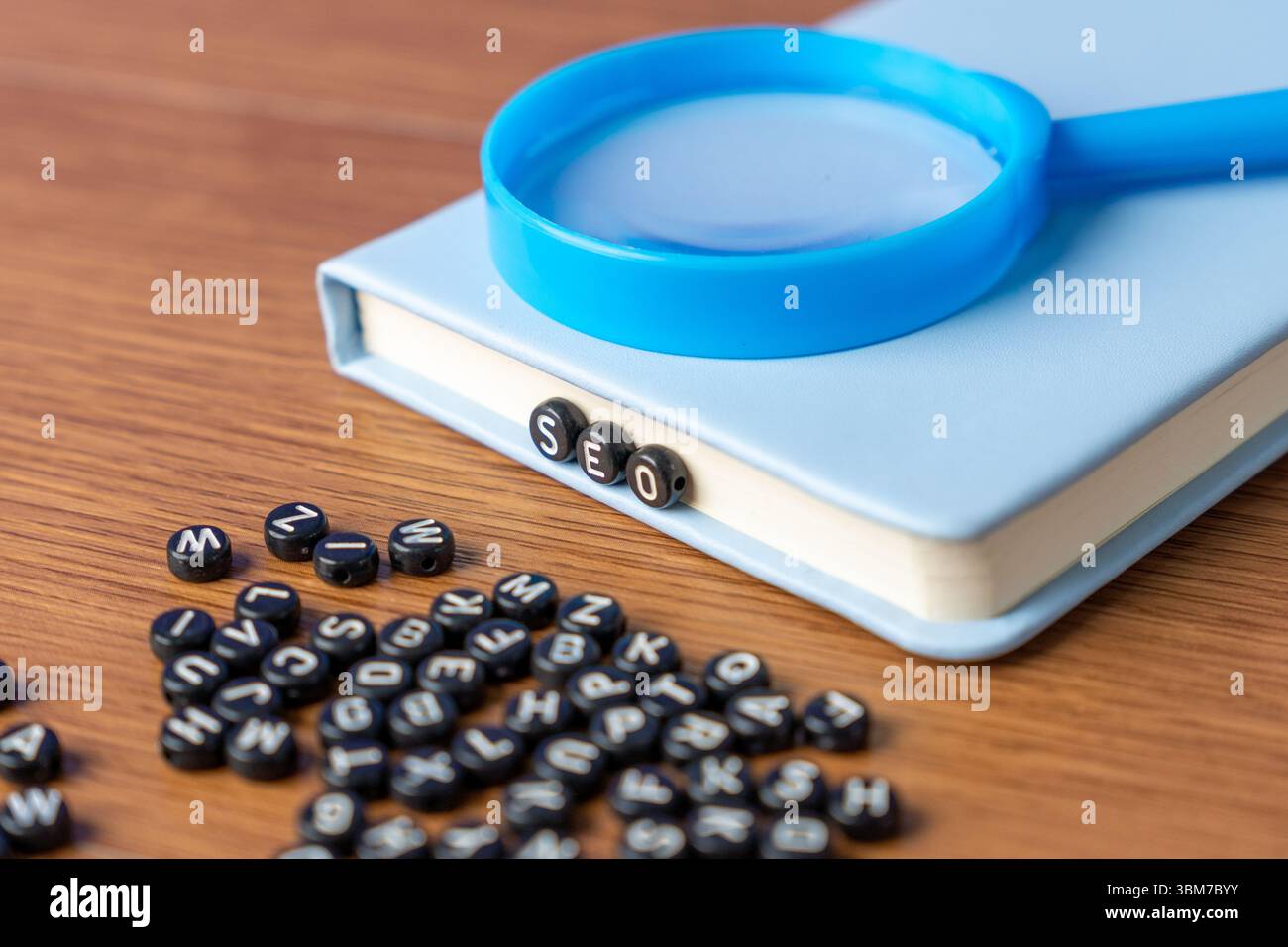 Perles alphabet orthographiant 'SEO' avec des perles plus dispersées sur une table en bois. Marketing numérique, analyse de données et concept de découverte d'informations. Banque D'Images