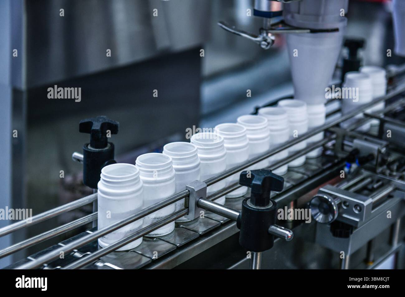 Gros plan comptage et machine d'embouteillage automatique de comprimés dans la ligne de production de l'industrie pharmaceutique Banque D'Images Gros plan comptage et machine d'embouteillage automatique de comprimés dans la ligne de production de l'industrie pharmaceutique Banque D'Images