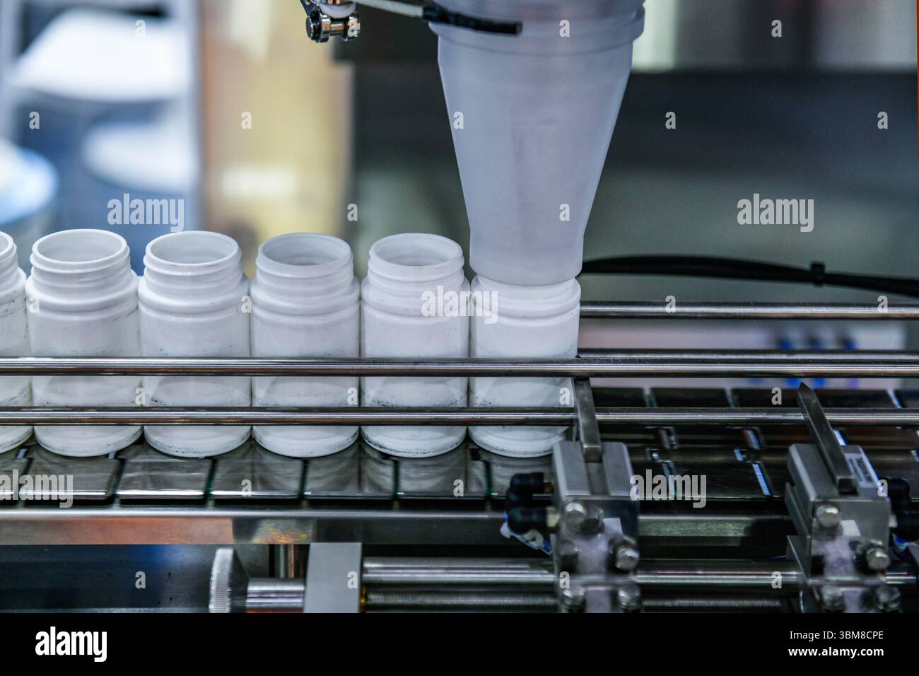 Gros plan comptage et machine d'embouteillage automatique de comprimés dans la ligne de production de l'industrie pharmaceutique Banque D'Images Gros plan comptage et machine d'embouteillage automatique de comprimés dans la ligne de production de l'industrie pharmaceutique Banque D'Images