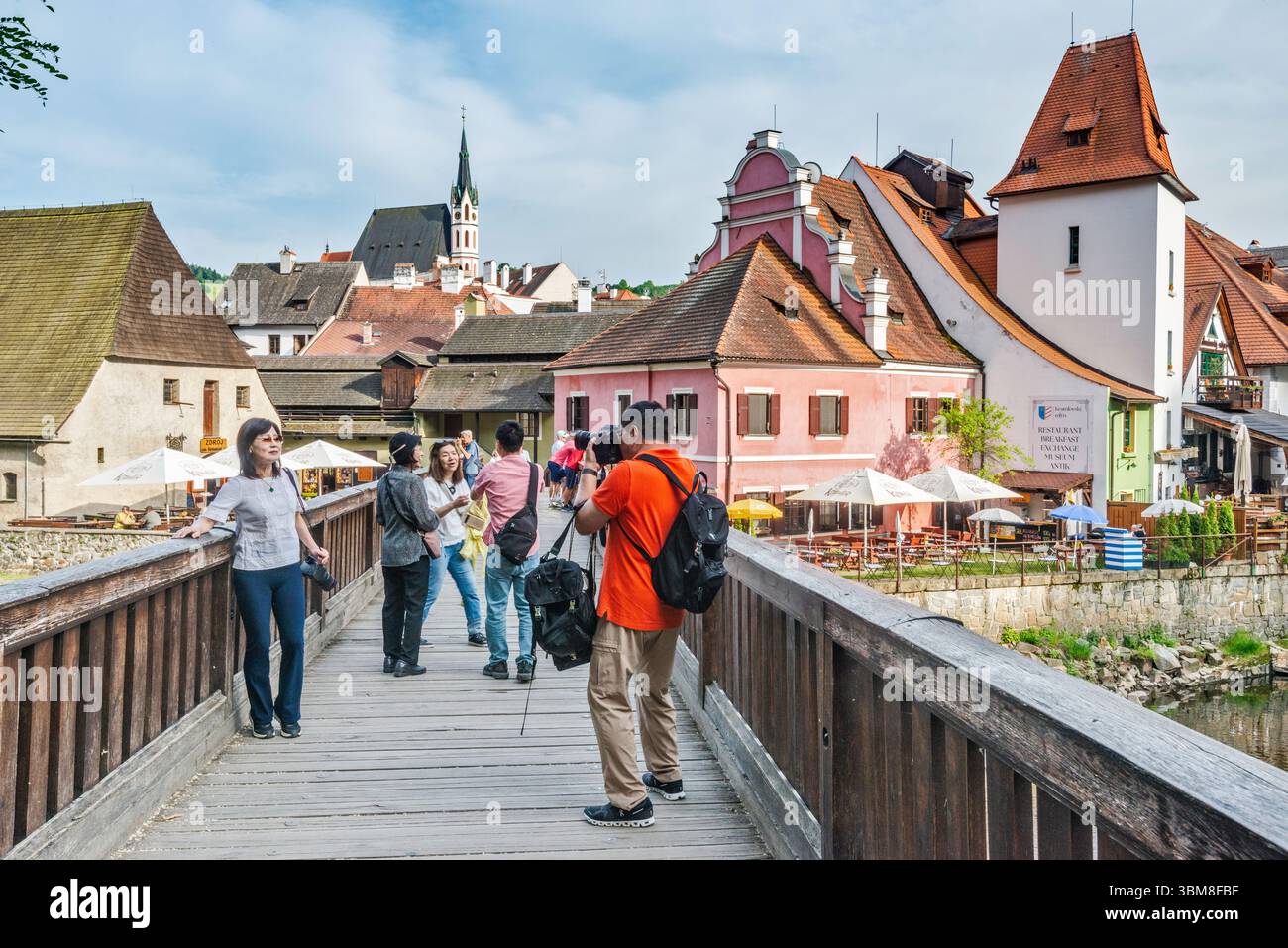 Touristes au pont Lavka pod Zamkem sur la rivière Vltava en dessous du château, ville intérieure en arrière-plan, église St Vitus à dist, Český Krumlov, Bohême, Tchéquie Banque D'Images