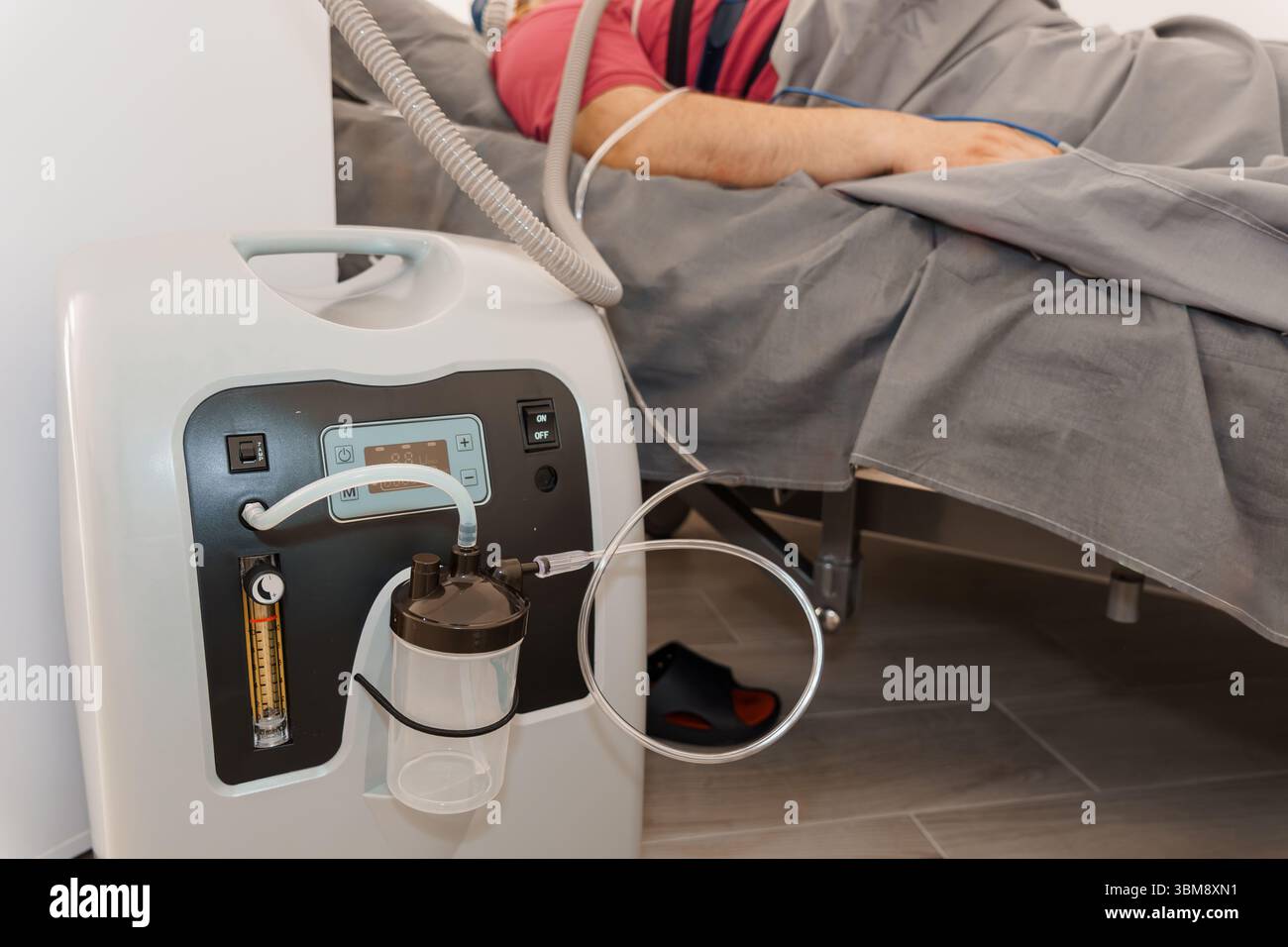 Un patient est allongé dans un lit d'hôpital relié à un concentrateur d'oxygène muni d'une canule nasale. prise de vue focalisée sur l'équipement médical, illustration Banque D'Images