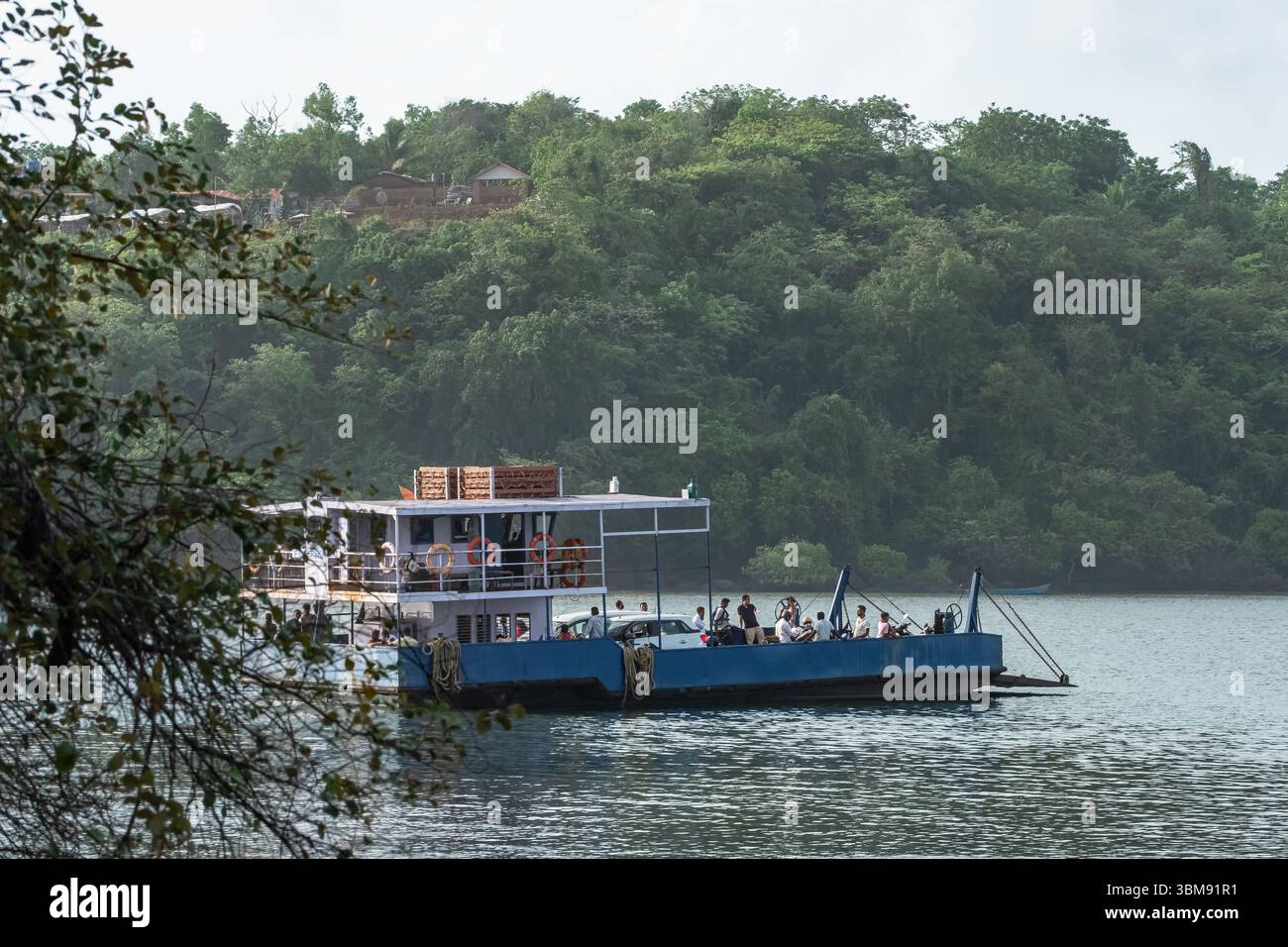 Ferry avec des gens et des voitures traversant la rivière. Un ferry traverse la rivière Terekhol à Goa en Inde. Photo de voyage, éditorial-mai 31,2025 Banque D'Images