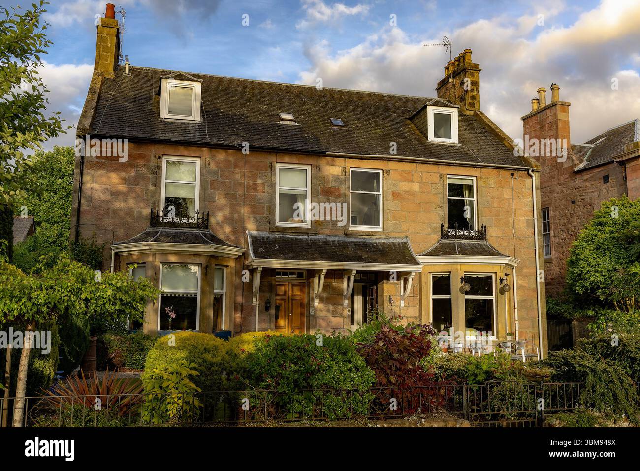 Une charmante maison traditionnelle en pierre avec un jardin luxuriant dans la pittoresque ville d'Inverness, en Écosse. Banque D'Images