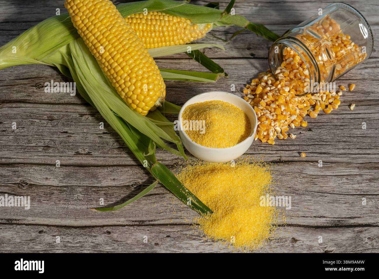 Épis de maïs, grains et farine reposant sur une table en bois rustique Banque D'Images