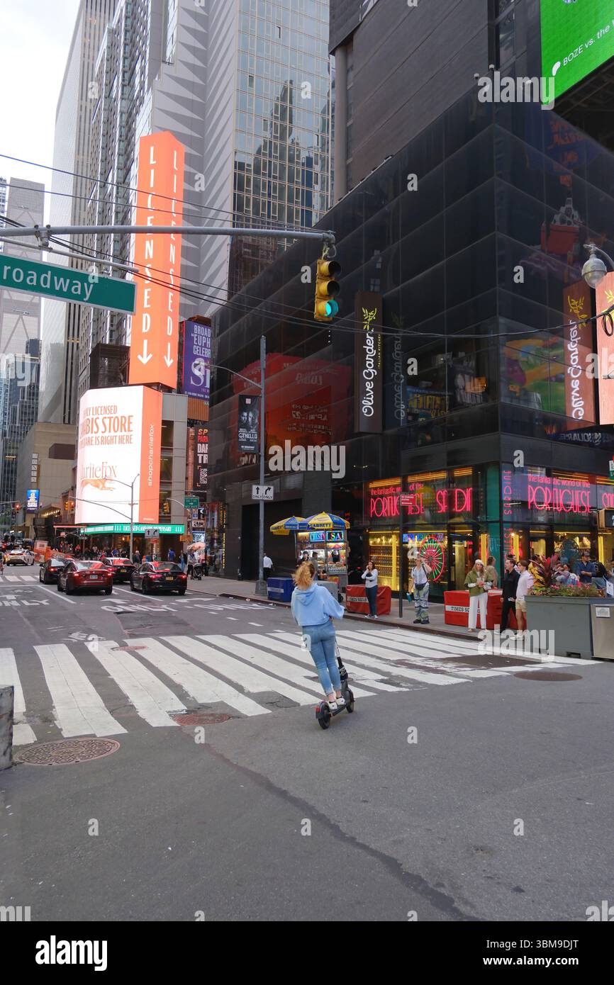 Jeune femme sur un scooter électrique - Broadway 42nd Street - New-York City, juin 2025 Banque D'Images