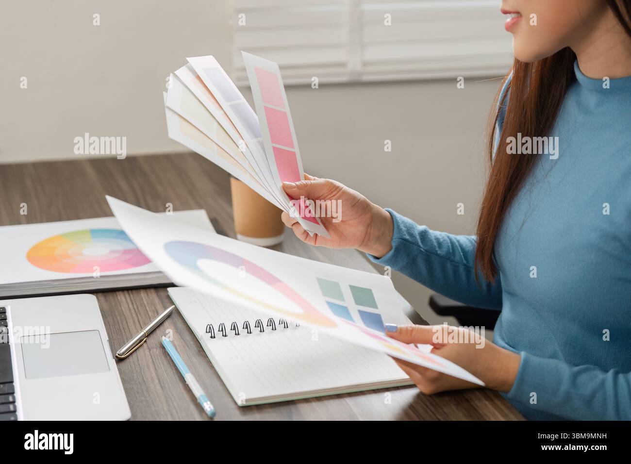 Consultation et création de couleurs. Un designer analysant divers échantillons de couleurs pour créer un design inspirant. Banque D'Images