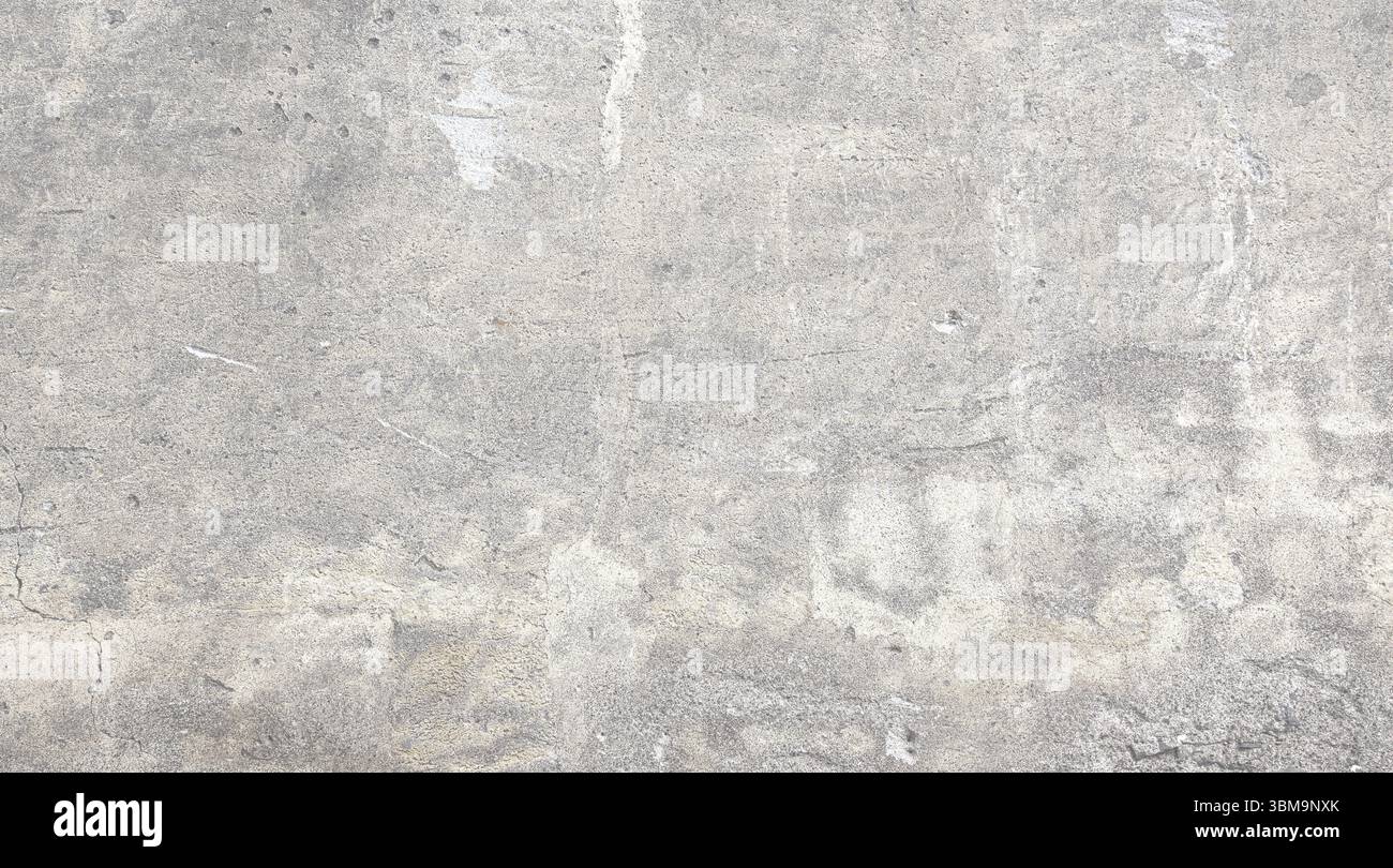 Vue rapprochée d'un mur de béton gris révélant une surface texturée marquée par l'âge, l'usure et diverses imperfections, adaptée aux arrière-plans et au design Banque D'Images