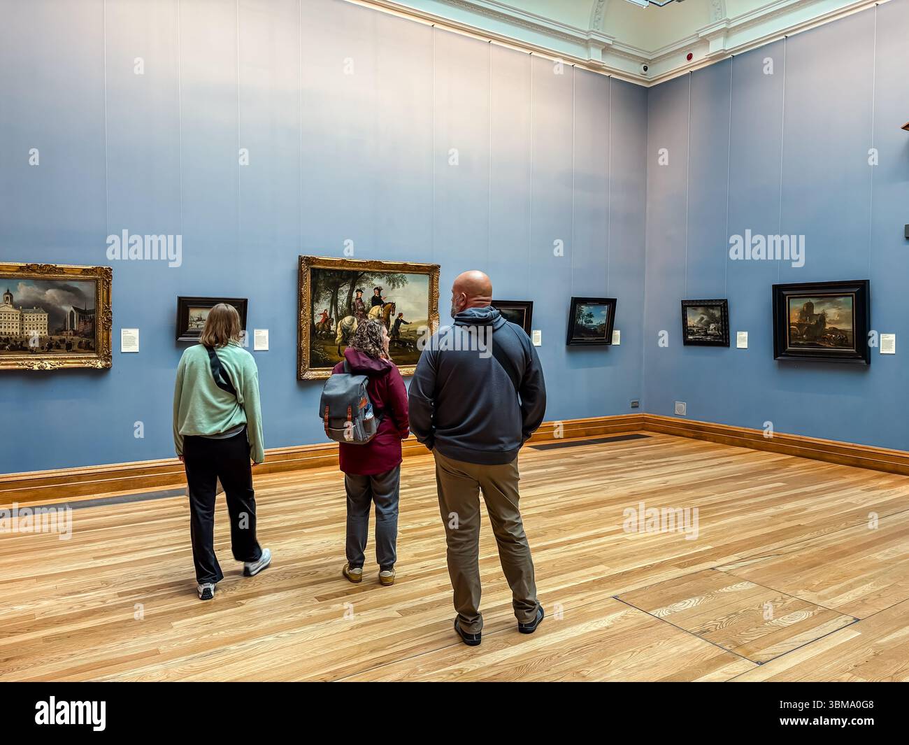 Galerie nationale. Les gens regardent des peintures dans une salle d'exposition avec des murs bleu clair et du parquet. Dublin, Irlande. Banque D'Images