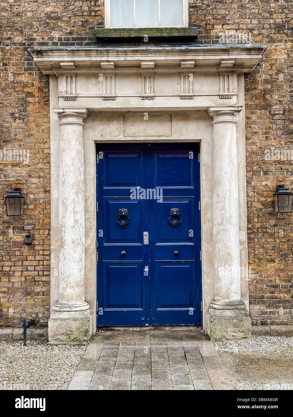 Entrée de porte de style géorgien à Dublin, Irlande. Détail de l'architecture historique avec des portes doubles bleues, des colonnes de pierre, et des frappeurs de tête de lion. Banque D'Images