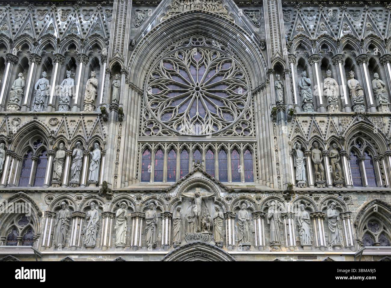 Figures sculptées en pierre et vitrail dans la façade de la cathédrale de Trondheim, Norvège Banque D'Images