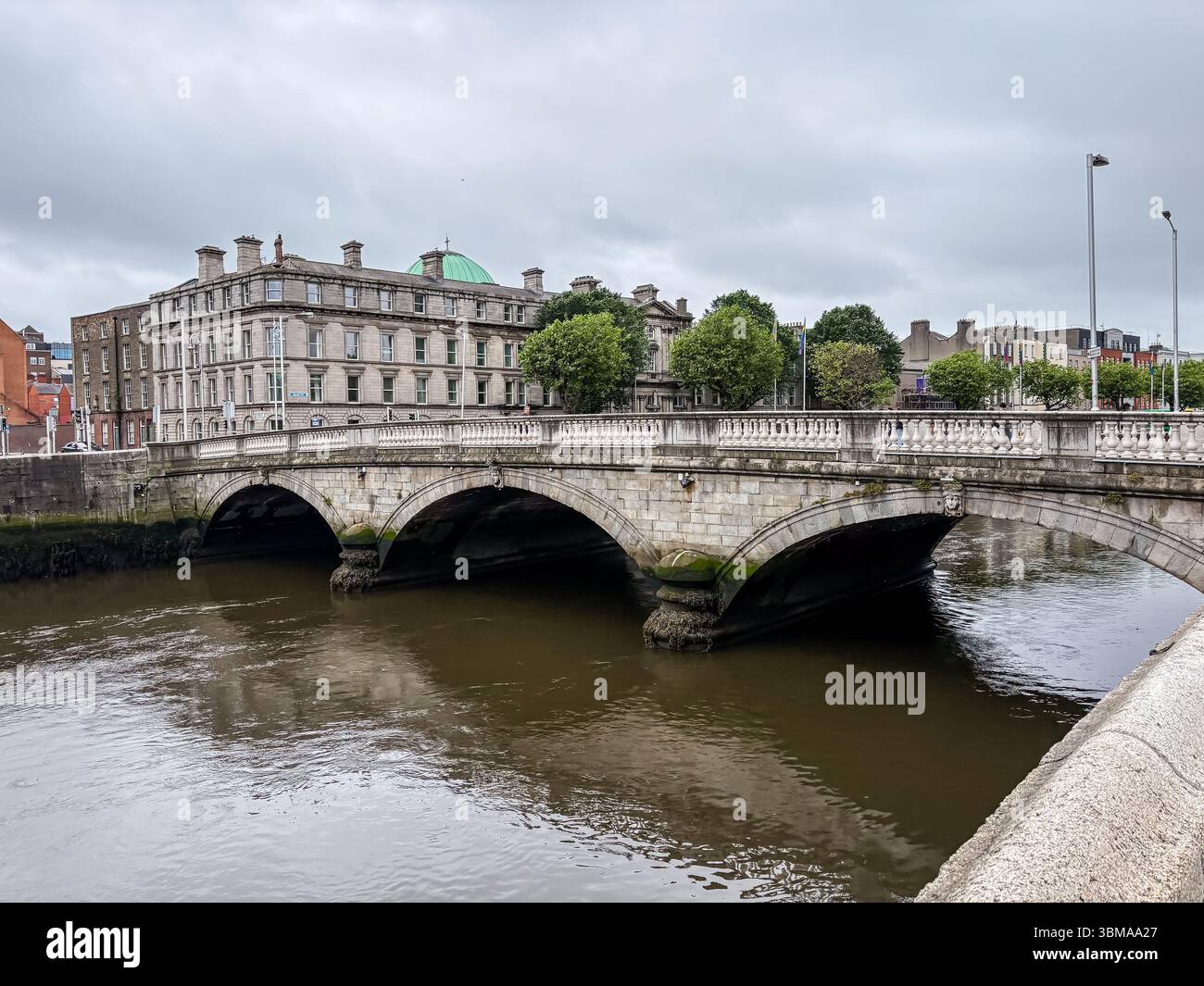 Pont O'Donovan Rossa. Pont en pierre sur la rivière Liffey à Dublin, Irlande, avec une architecture historique visible en arrière-plan. Banque D'Images