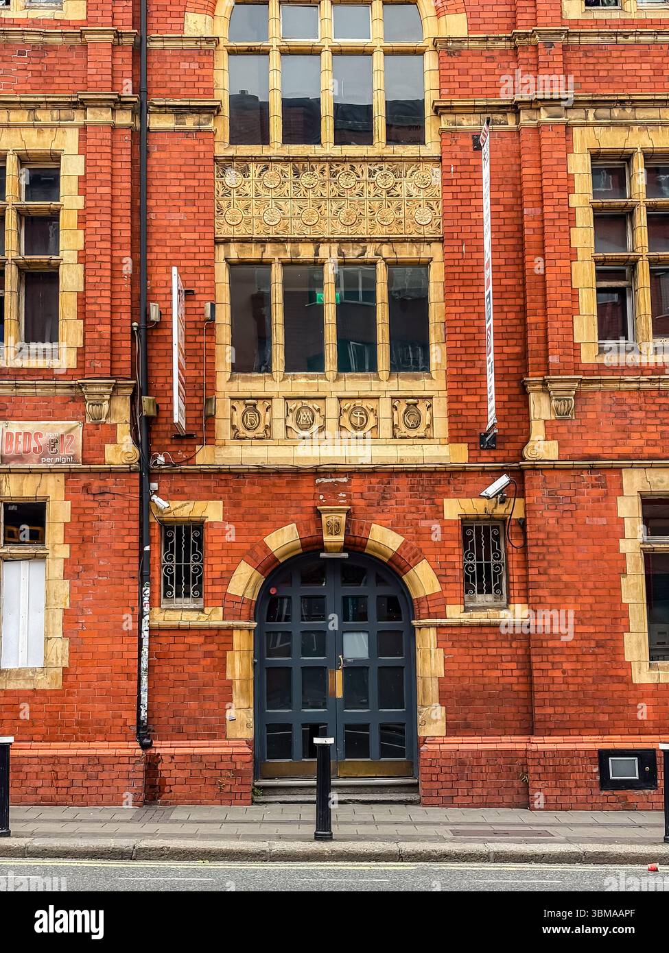 Façade de bâtiment en briques rouges avec détails jaunes ornés et porte voûtée à Dublin, Irlande. Architecture historique de la ville européenne. Banque D'Images