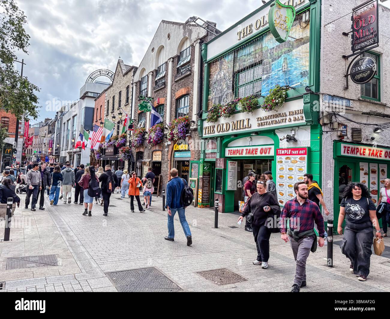 Temple Bar à Dublin, Irlande, montrant une rue animée avec des pubs traditionnels, des restaurants, des boutiques et de nombreux piétons. Banque D'Images