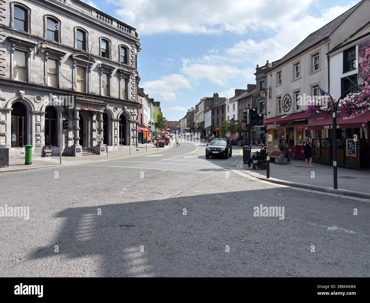 Scène de rue à Kilkenny, en Irlande, avec une architecture historique, des boutiques et des piétons par une journée ensoleillée. Banque D'Images