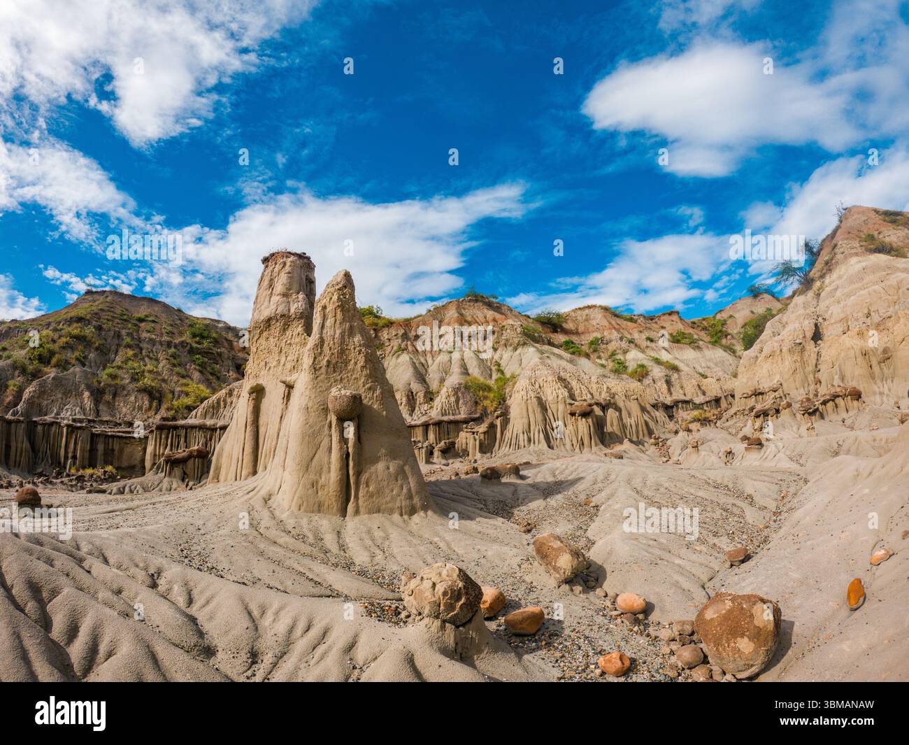 Vue imprenable sur les formations rocheuses uniques et le terrain sablonneux du désert de Tatacoa à Huila, en Colombie, sous un ciel bleu vibrant. Banque D'Images
