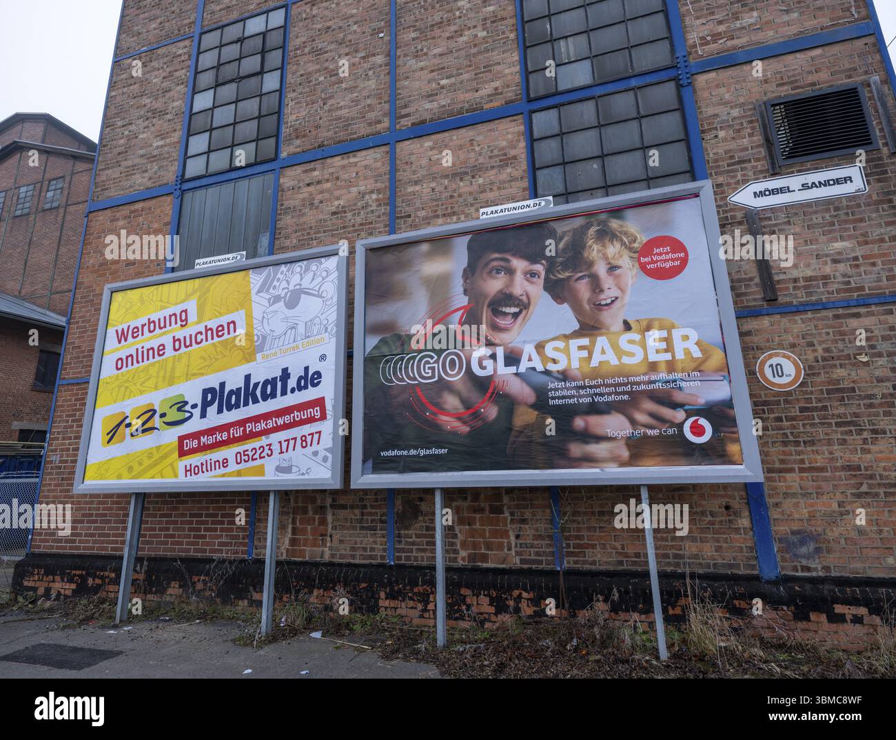 Grandes affiches avec de la publicité pour les panneaux d'affichage et la fibre optique de Vodafone sur le mur d'un bâtiment industriel, Braunschweig, basse-Saxe, allemand Banque D'Images